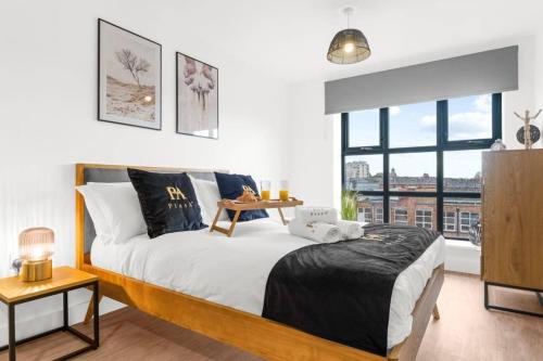 a bedroom with a bed and a large window at Pluxa Onyx Luxury 1 bedroom apartment in Birmingham