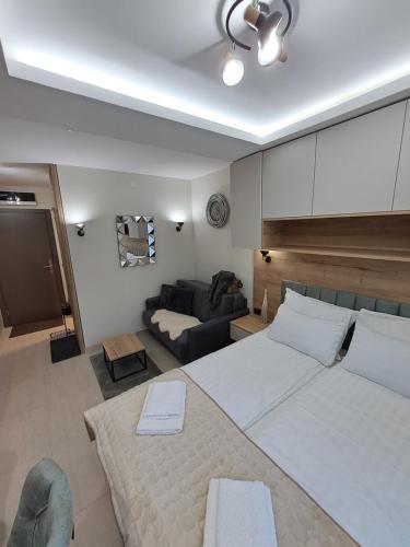 a bedroom with a large bed and a couch at Lux apartmani Dunja Kopaonik Čardaci - GREEN in Kopaonik