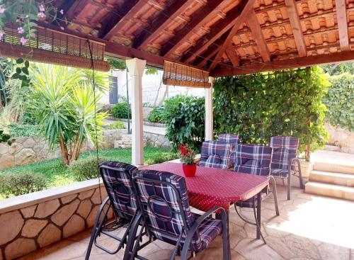 a patio with a table and chairs under a pergola at Apartments Ita - Postira in Postira