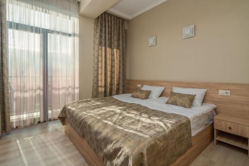 una camera con un letto e una grande finestra di Hotel Alexandria a Saguramo