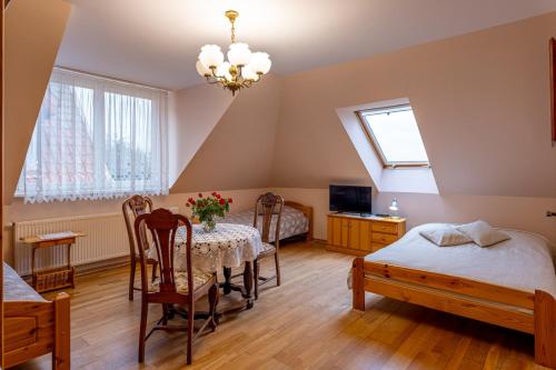 a dining room with a table and chairs in a room at Pensjonat nad Płaskim in Jerzwałd