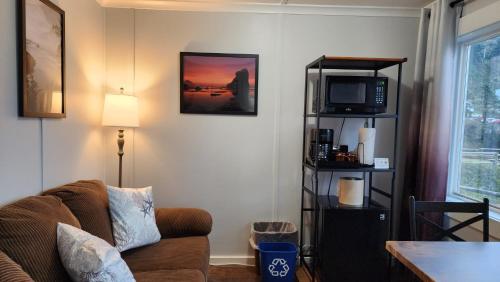 a living room with a couch and a tv at Inn at Arch Rock in Depoe Bay