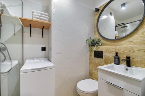 a bathroom with a toilet and a sink and a mirror at Apartament 4 Pory Roku PRZY PLAŻY Z WIDOKIEM NA MORZE in Gdynia