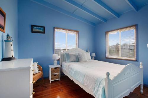 a blue bedroom with a white bed and a lighthouse at Family Retreat 500m to the beach in Ocean Grove
