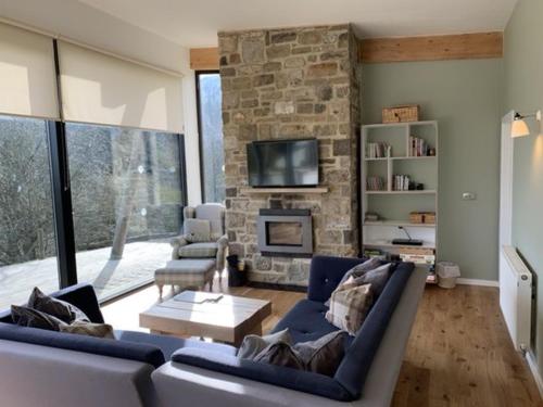 a living room with a couch and a stone fireplace at Yorkshire Dales Lodge 17 by Together Travel - 3-Bed Premium Family in Richmond
