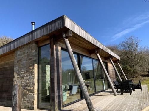 a house with glass windows on a wooden deck at Yorkshire Dales Lodge 17 by Together Travel - 3-Bed Premium Family in Richmond