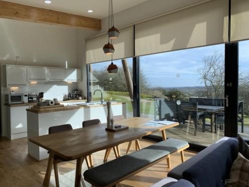 a kitchen and living room with a wooden table and chairs at Yorkshire Dales Lodge 17 by Together Travel - 3-Bed Premium Family in Richmond