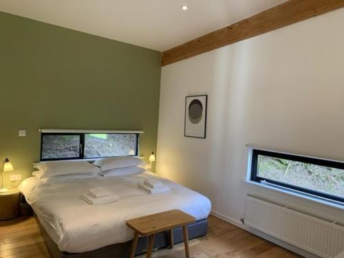 a bedroom with a bed with a table and two windows at Yorkshire Dales Lodge 17 Premium Ensuite in Richmond