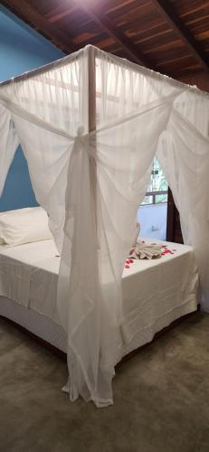 a bedroom with a bed covered in white mosquito nets at Pipa Blue in Pipa