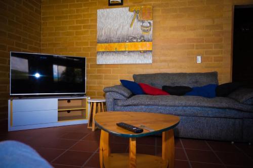 a living room with a couch and a flat screen tv at Casa Del Viento, Alojamiento in Villanueva