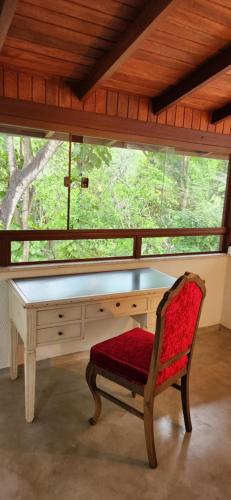a desk with a chair in front of a window at Pipa Blue in Pipa
