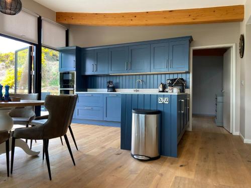 uma cozinha com armários azuis e uma mesa e cadeiras em Yorkshire Dales Lodge 18 Premium Family em Richmond