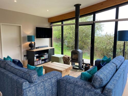 uma sala de estar com dois sofás azuis e uma lareira em Yorkshire Dales Lodge 18 Premium Family em Richmond