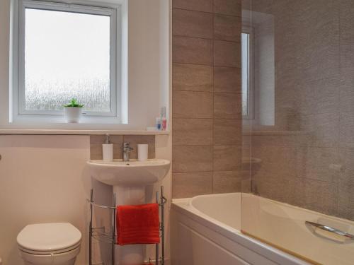 a bathroom with a sink and a toilet and a bath tub at Eddleston Cottage - Reading in Reading