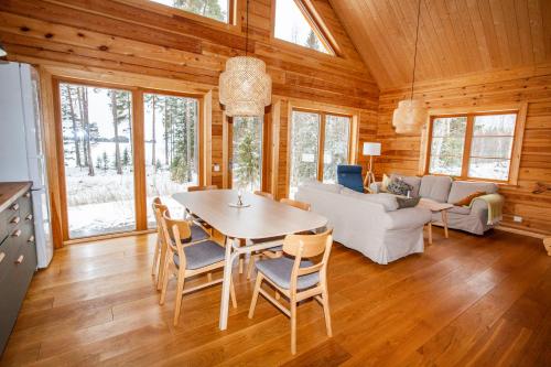 - une salle à manger et un salon avec une table et des chaises dans l'établissement Blockhaus am See - Komfort umgeben von Natur!, à Nälden