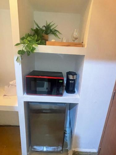 a microwave on a white shelf in a kitchen at Studio 27 Colonial, Centro Histórico in Santo Domingo