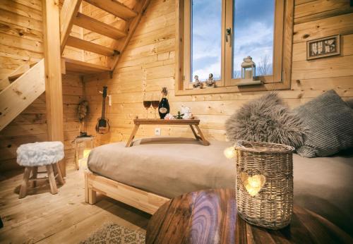 ein Schlafzimmer mit einem Bett in einer Holzhütte in der Unterkunft Father's Land in Rakovica