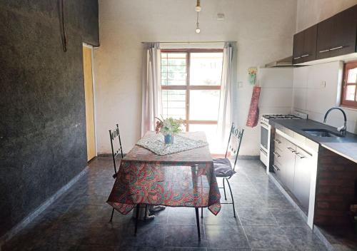 cocina con mesa con sillas y fregadero en Casa Alta Gracia - 3 Habitaciones para 6 personas en Alta Gracia