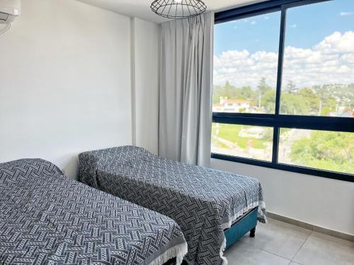 une chambre avec un lit et une grande fenêtre dans l'établissement PASEO QUATTRO, à Villa Carlos Paz