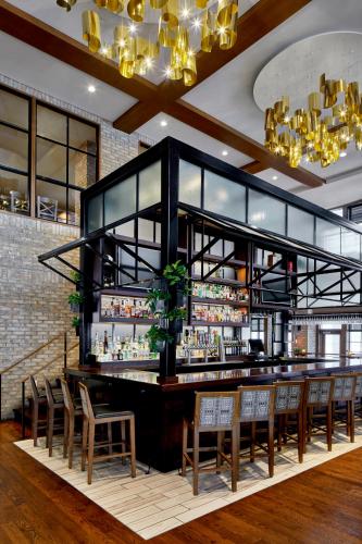 a bar in a restaurant with chairs and lights at The Hotel Landing in Wayzata