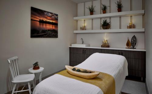 a bedroom with two beds and a sink and a table at The Hotel Landing in Wayzata