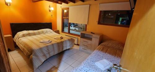 Habitación pequeña con 2 camas y ventana en Habitacion privada en casa de familia en Ushuaia