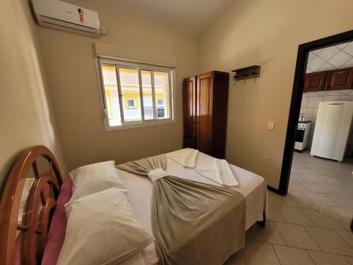 - une chambre avec un lit et une fenêtre dans l'établissement Pousada Genoveva - Apto com dois dormitórios, à Laguna