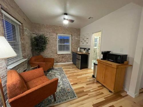 ein Wohnzimmer mit einem Sofa und einer Küche in der Unterkunft Brick Street Apartment-Studio Suite in Augusta