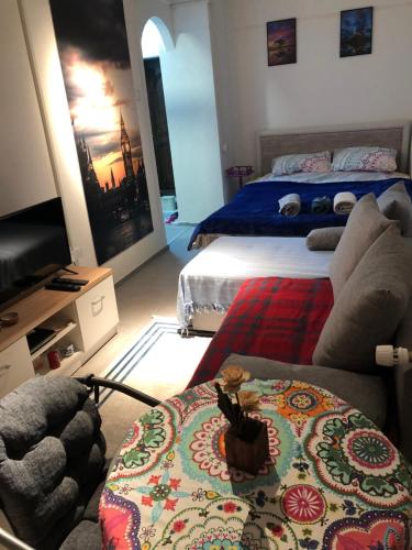 ein Wohnzimmer mit einem Bett, einem Sofa und einem Tisch in der Unterkunft Hana’s Apartment in Pristina