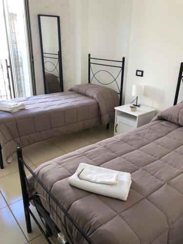 sypialnia z 2 łóżkami i białym ręcznikiem na łóżku w obiekcie Terrazza famà w Katanii