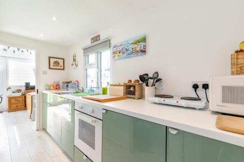 a kitchen with a white counter top and a sink at The Happy Hedgehog in Mundesley