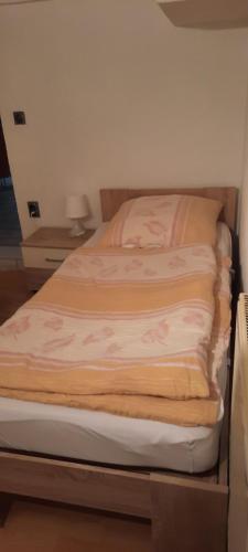 1 cama no hecha en un dormitorio con mesita de noche en Ostermanns Apartment, en Bretten
