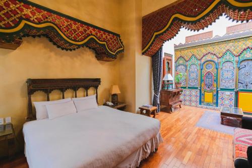 ein Schlafzimmer mit einem großen Bett und einer farbenfrohen Wand in der Unterkunft La Casa de la Marquesa in Querétaro