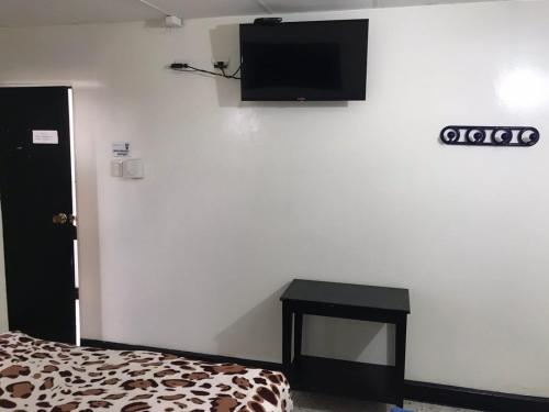 a room with a bed and a tv on a wall at HOTEL LOS GUADUALES in Barranquilla