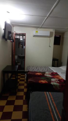 a hotel room with two beds and a checkered floor at HOTEL LOS GUADUALES in Barranquilla