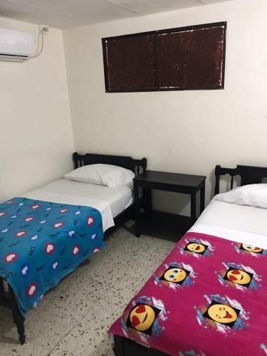 a bedroom with two beds with hello kitty sheets at HOTEL LOS GUADUALES in Barranquilla