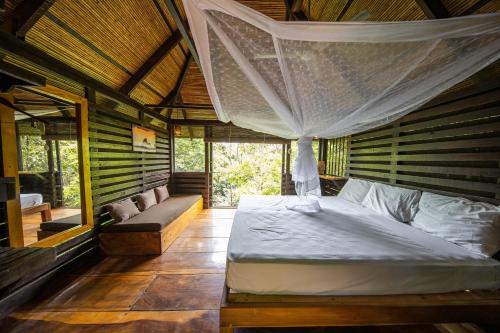 a bedroom with a bed with a mosquito net at Buena Vista Surf Club in El Plantel