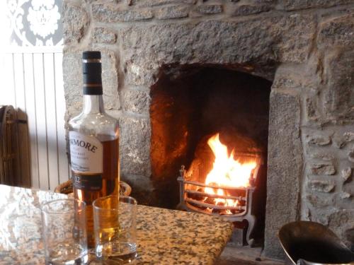 a bottle of wine sitting on a table in front of a fireplace at Inn At The Park Hotel in Aberdeen