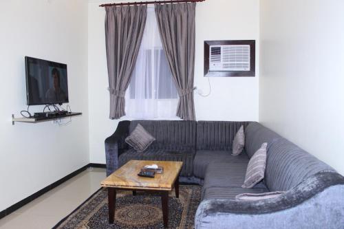 sala de estar con sofá y mesa de centro en فخامة الديار للشقق المخدومة Fakhamat Aldyar For Serviced Apartments, en Taif