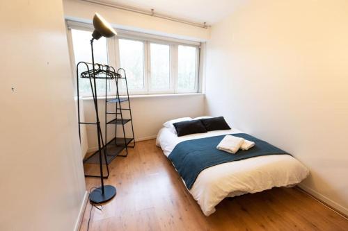 een slaapkamer met een bed en een vloerlamp bij Le Jitaku- Magnifique Duplex - 15min Disneyland in Lognes