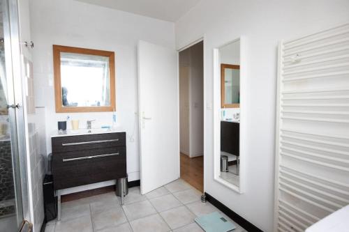 een badkamer met een wastafel en een spiegel bij Le Jitaku- Magnifique Duplex - 15min Disneyland in Lognes