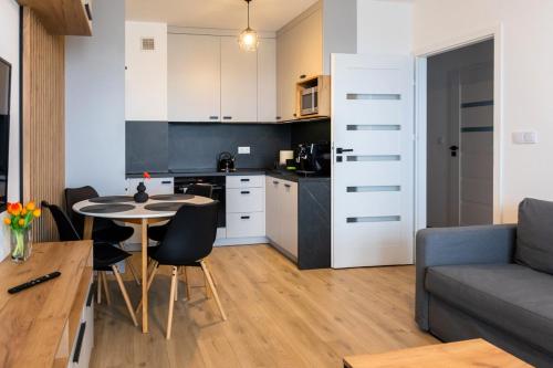 cocina y sala de estar con mesa y sillas. en Apartament przy PILECKIEGO 34 en Biała Podlaska