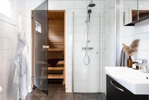 a bathroom with a shower and a sink at Beautiful house with sea view in Piteå