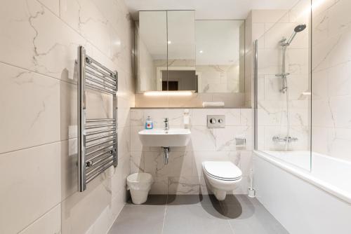 a bathroom with a sink and a toilet and a shower at The Hunt Cherrywood in Loughlinstown