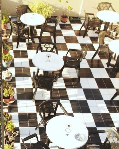 un restaurante con mesas y sillas en un suelo a cuadros en Telmotango Hotel en Buenos Aires