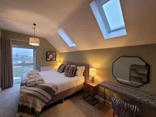 una camera con letto, specchio e finestra di Rowan House, Ashlin Farm Barns a Lincoln