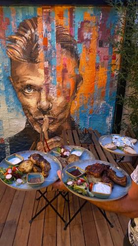 a person holding plates of food in front of a painting at Penzion Panská in České Budějovice