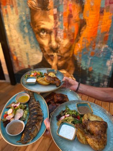 a person holding three plates of food on a table at Penzion Panská in České Budějovice