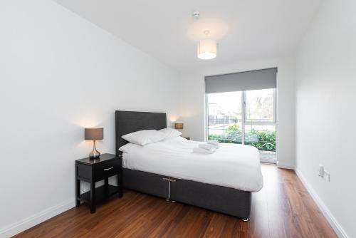 1 dormitorio con cama blanca y ventana en Fernbank, en Dublín