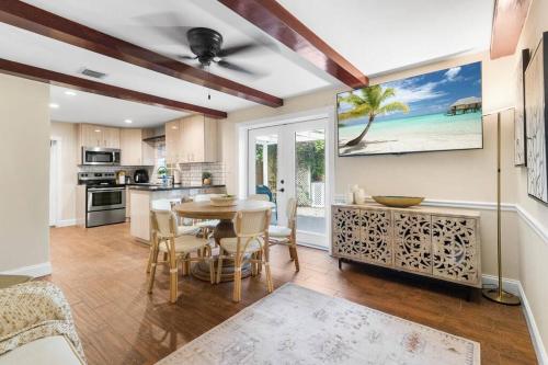 a kitchen and dining room with a table and chairs at Tropical Oasis Located Near Lake With Pool and Hot Tub in West Palm Beach